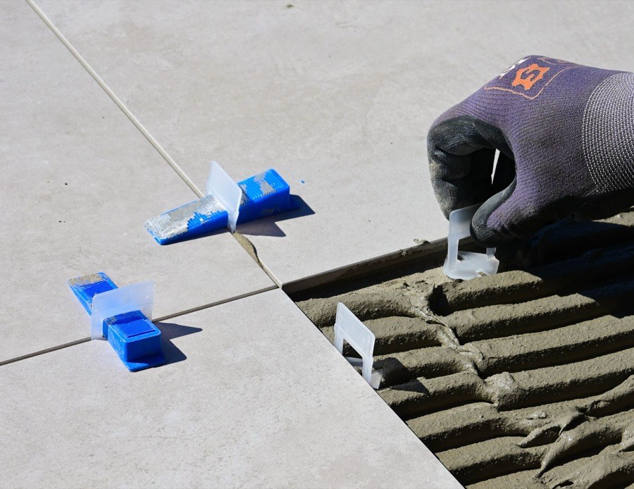 A detailed close-up shot of an uneven tile joint, showing a distinct vertical offset between the edges of two adjacent tiles, illustrating lippage.